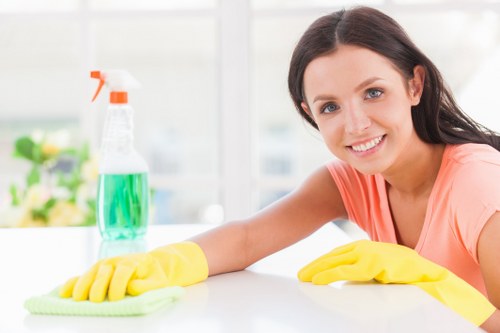 Cleaner using safe procedures and protective measures in a workplace setting